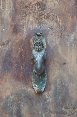Image showing Old iron handle shaped like a woman stuck in an old port that is