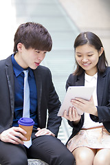 Image showing Young Asian female and male business executive using table