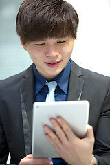 Image showing Young Asian male business executive using table