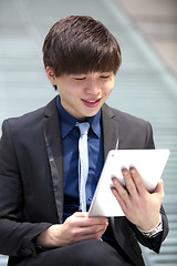 Image showing Young Asian male business executive using table
