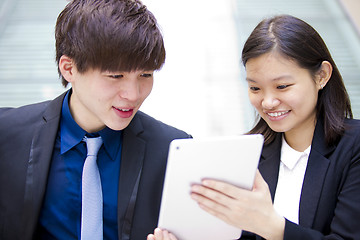 Image showing Young Asian female and male business executive using table