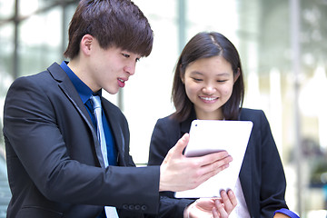 Image showing Young Asian female and male business executive using table