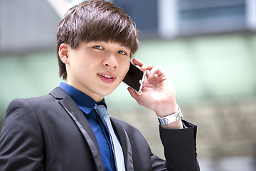 Image showing Young Asian male business executive using smart phone