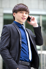 Image showing Young Asian male business executive using smart phone