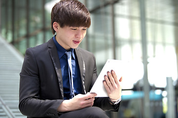 Image showing Young Asian male business executive using tablet