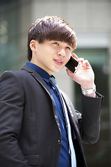 Image showing Young Asian male business executive using smart phone