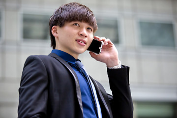 Image showing Young Asian male business executive using smart phone