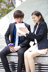 Image showing Young Asian female and male business executive using tablet