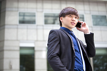 Image showing Young Asian male business executive using smart phone