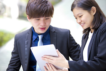 Image showing Young Asian female and male business executive using tablet