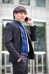 Image showing Young Asian male business executive using smart phone