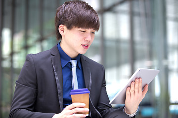 Image showing Young Asian male business executive using tablet