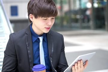 Image showing Young Asian male business executive using tablet
