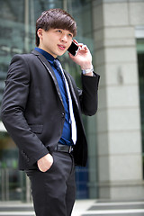 Image showing Young Asian male business executive using smart phone
