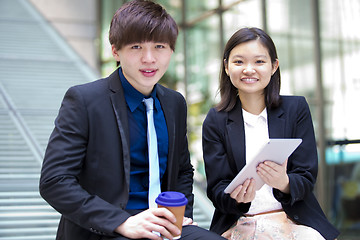 Image showing Young Asian female and male business executive using tablet