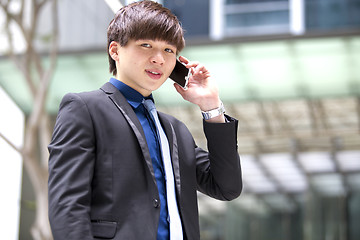 Image showing Young Asian male business executive using smart phone