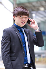 Image showing Young Asian male business executive using smart phone