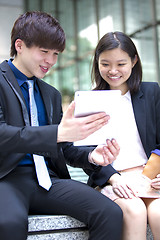 Image showing Young Asian female and male business executive using tablet