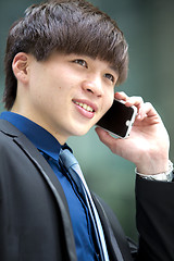 Image showing Young Asian male business executive using smart phone