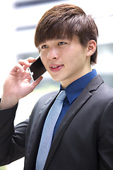 Image showing Young Asian male business executive using smart phone