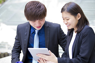 Image showing Young Asian female and male business executive using tablet