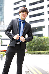 Image showing Young Asian business executive in suit smiling portrait