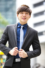 Image showing Young Asian business executive in suit smiling portrait