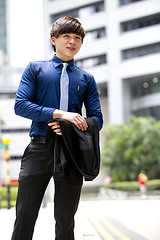 Image showing Young Asian business executive in suit smiling portrait