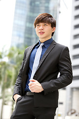 Image showing Young Asian business executive in suit smiling portrait