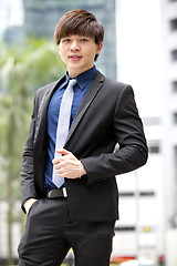 Image showing Young Asian business executive in suit smiling portrait