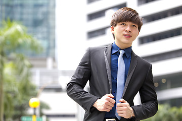 Image showing Young Asian business executive in suit smiling portrait