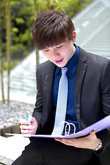 Image showing Young Asian business executive in suit holding file