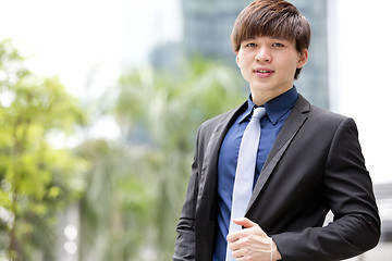 Image showing Young Asian business executive in suit smiling portrait