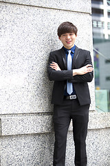 Image showing Young Asian business executive in suit smiling portrait