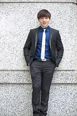 Image showing Young Asian business executive in suit smiling portrait