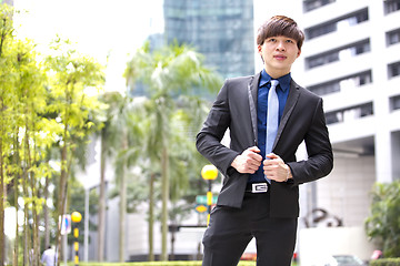 Image showing Young Asian business executive in suit smiling portrait