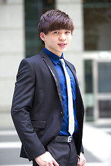 Image showing Young Asian business executive in suit smiling portrait