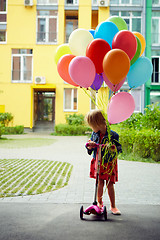 Image showing happy little girl outdoors with balloons