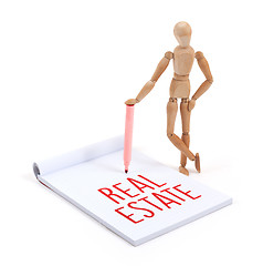 Image showing Wooden mannequin writing - Real estate