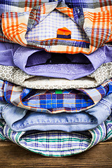 Image showing cotton shirts on a wooden shelf in a clothes store