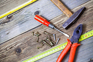 Image showing Old hammer, pliers, yellow measuring tape, vintage screwdriver a