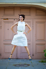 Image showing Smiling beautiful middle-aged woman in the white dress flying