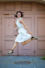 Image showing beautiful brunette  jumped in a white dress