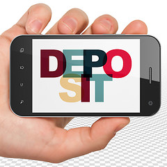 Image showing Currency concept: Hand Holding Smartphone with Deposit on  display