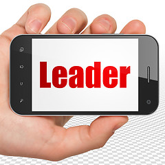 Image showing Business concept: Hand Holding Smartphone with Leader on display