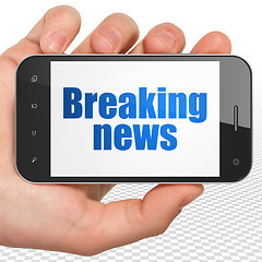 Image showing News concept: Hand Holding Smartphone with Breaking News on display