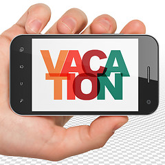 Image showing Tourism concept: Hand Holding Smartphone with Vacation on  display