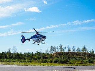 Image showing Police helicopter from norwegian authorities hoovering over land