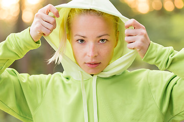 Image showing Confident sporty woman wearing fashionable green hoodie. 