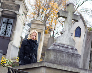 Image showing Solitary woman visiting relatives grave.